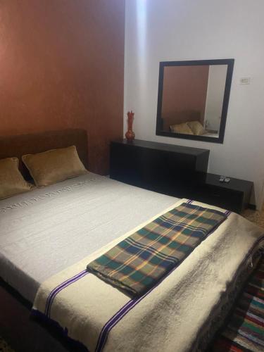 a bedroom with a bed with a mirror on the wall at Dar kouka in Tataouine