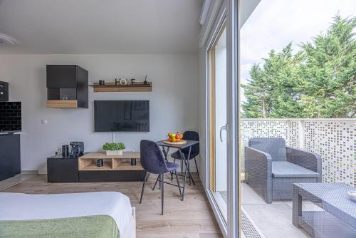 une chambre avec un lit, une table et des chaises dans l'établissement Studio entre Paris & Disneyland, à Noisy-le-Grand