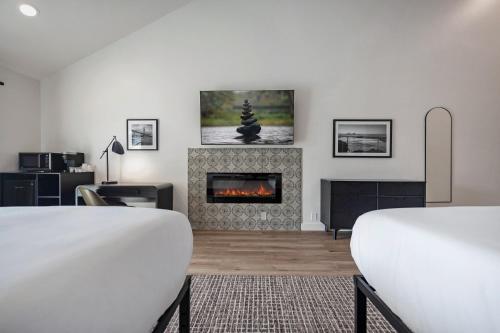a living room with two beds and a fireplace at Bodega Coast Inn and Suites in Bodega Bay