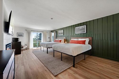 two beds in a room with green walls at Bodega Coast Inn and Suites in Bodega Bay
