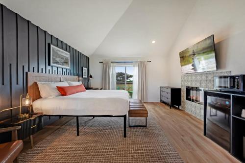 a bedroom with a large bed and a tv at Bodega Coast Inn and Suites in Bodega Bay