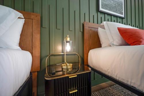 a bedroom with two beds and a table with a lamp at Bodega Coast Inn and Suites in Bodega Bay