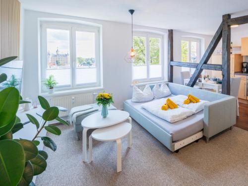 a living room with a couch and a table at Schlosskönig - Modernes & zentrales Apartment mit Balkon und Arbeitsplatz in Schwerin