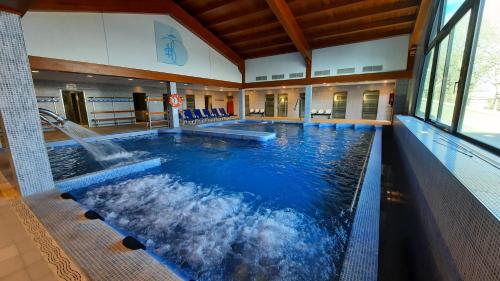 a large swimming pool with a fountain in a building at Apartamentos Baños de Ledesma in Salamanca