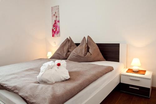a white stuffed animal is sitting on a bed at Erlachmühle in Mondsee