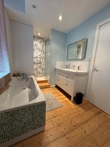 une salle de bain avec une baignoire, un lavabo et un miroir dans l'établissement Maison rénovée 7P Proche de Lille, à Tourcoing