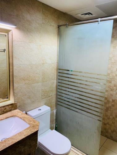 a bathroom with a shower and a toilet and a sink at Lavish Private Rooms in Sharjah