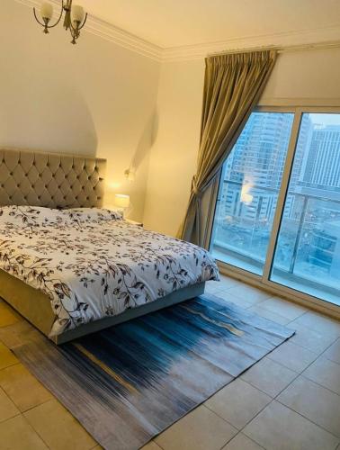 a bedroom with a bed and a large window at Lavish Private Rooms in Sharjah