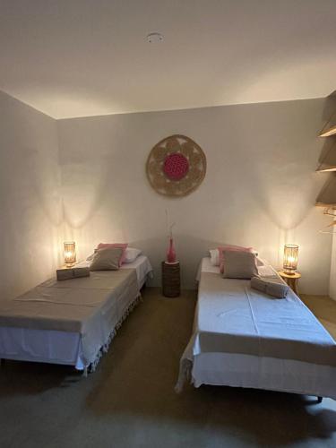 a bedroom with two beds and a clock on the wall at Casa Bela Vida in Fortim