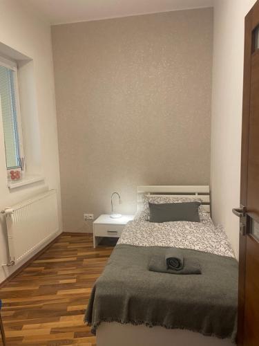 a bedroom with a bed and a wooden floor at Apartmán Hodžova in Trenčín
