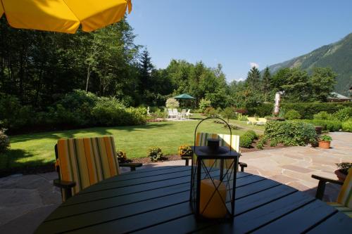 a wooden table with an umbrella and two chairs at Hotel Garni Erler in Mayrhofen