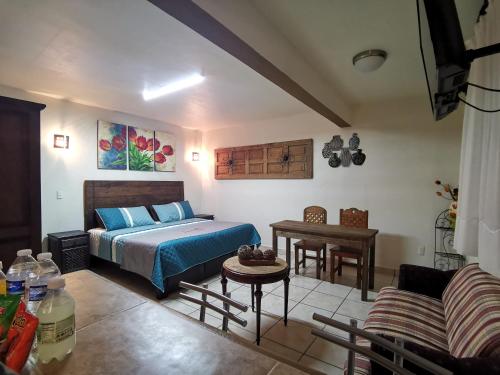 ein Schlafzimmer mit einem Bett, einer Couch und einem Tisch in der Unterkunft Terraza Suites - Adults Only in San Cristóbal de las Casas