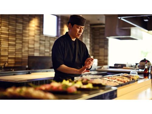 a man standing in a kitchen preparing food at Blanchette Nankishirahama - Vacation STAY 05732v in Kanayama