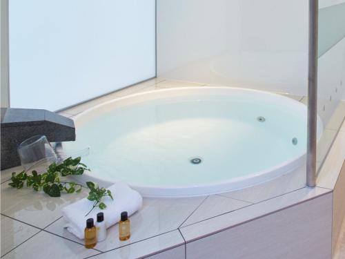 a bath tub in a bathroom with bottles of wine at Blanchette Nankishirahama - Vacation STAY 05732v in Kanayama