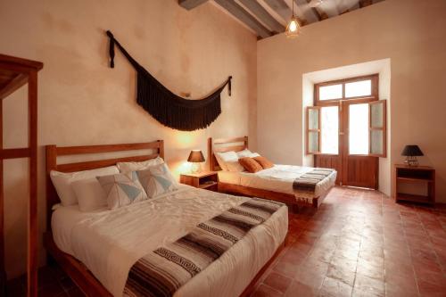 a bedroom with two beds and a window at Hotel Boutique Casa Jade in Campeche