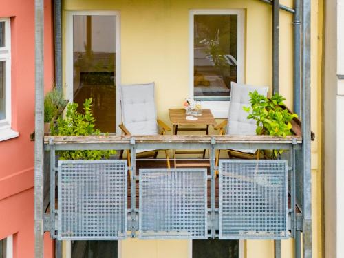 a balcony with chairs and a table on a building at Schlosskönig - Modernes & zentrales Apartment mit Balkon und Arbeitsplatz in Schwerin