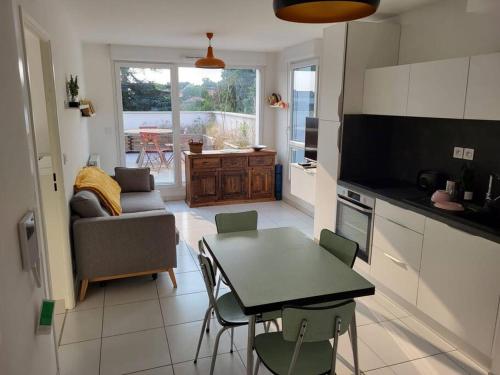 une cuisine et un salon avec une table et des chaises dans l'établissement Dassaut - Toulouse - CI - 2 pièces spacieux avec grande terrasse et vue dégagée, à Toulouse