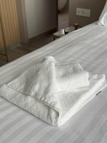 a white towel sitting on top of a bed at CityLuxe Center Ioannina in Ioannina