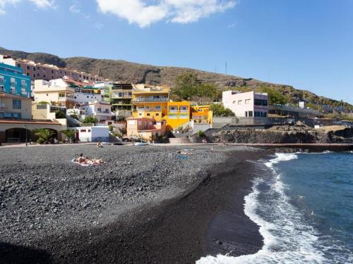 a group of people laying on a beach next to the water at Live Candelaria Tamonante in Candelaria