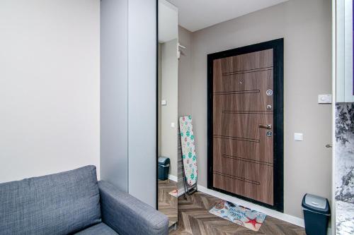 sala de estar con sofá y puerta de madera en Tiny studio in center of Varna, en Varna