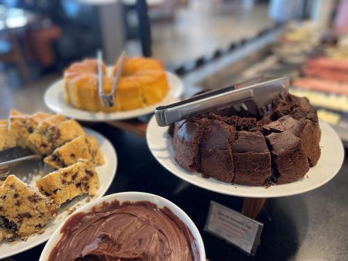a display of different types of cakes and pastries at Novotel Itu Terras de São José Golf & Resort in Itu