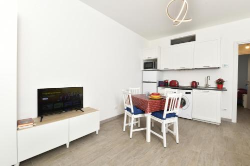 a kitchen and dining room with a table and a tv at Il Gioiello del Conte in Turin