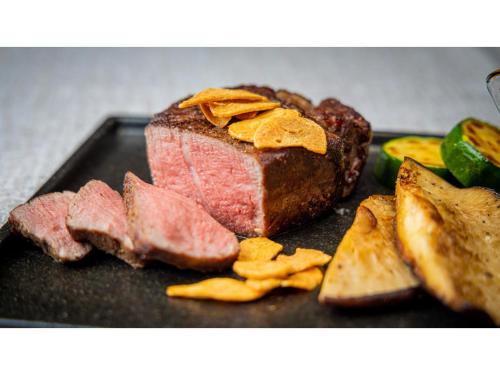 a piece of meat and chips on a black plate at Blanchette Nankishirahama - Vacation STAY 05733v in Kanayama
