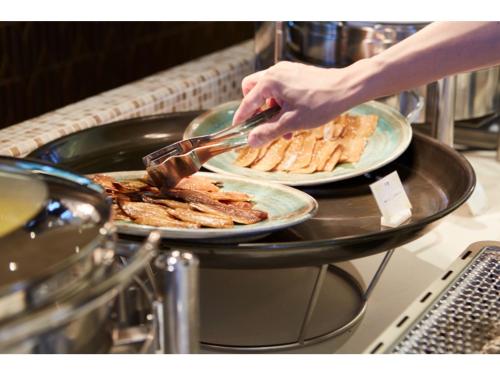 a person is preparing food on a table with plates of food at Blanchette Nankishirahama - Vacation STAY 05733v in Kanayama