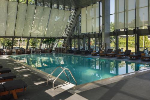 a large swimming pool in a building with windows at Crowne Plaza Belgrade by IHG in Belgrade