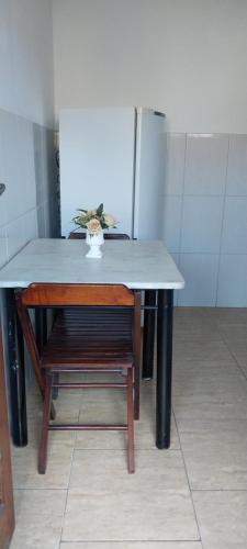 a table and a chair in a room at Verde Mar Abricó 2 in Rio das Ostras