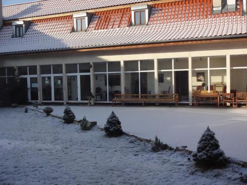 a house with snow on the ground in front of it at Kaštieľ Biela Dáma a Čierny Rytier in Krompachy