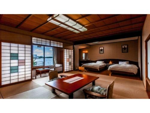加賀市にあるTokigasane - Vacation STAY 21014vのベッド2台とテーブル付きの部屋、ベッドルーム1室が備わるアパートメントです。