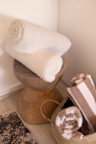 a pile of towels sitting on top of a toilet at Four Peaks Duplex - 4 Sleeper with Mountain Views, Balcony and Pool in Hout Bay Beachfront in Hout Bay