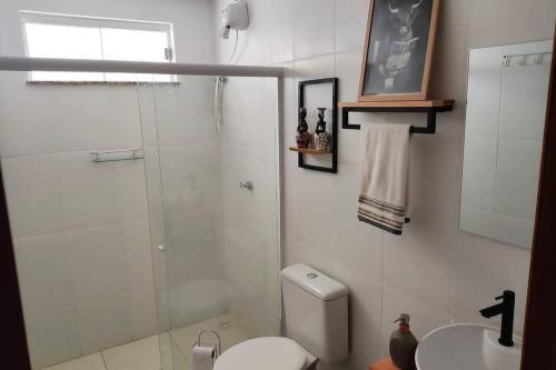 a bathroom with a shower and a toilet and a sink at Apto em Ilhéus - Pé na areia in Ilhéus