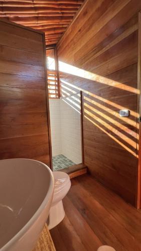 a bathroom with a toilet and a sink and a tub at Akwaba Lodge in The Gap