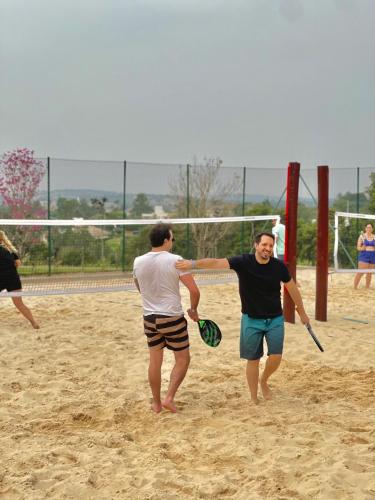 two men playing a game of volley ball on a beach at Novotel Itu Terras de São José Golf & Resort in Itu