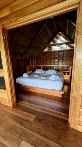 a bedroom with a bed in a wooden room at Akwaba Lodge in The Gap