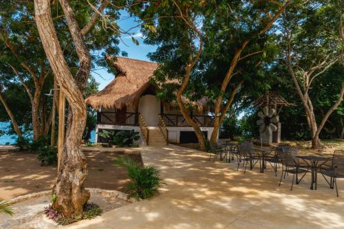 a pavilion with tables and chairs under trees at Casa Kaimari By SoHo in Cartagena de Indias