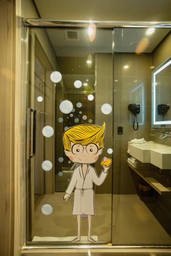 a bathroom with a painting of a person in a shower at Novotel Itu Terras de São José Golf & Resort in Itu