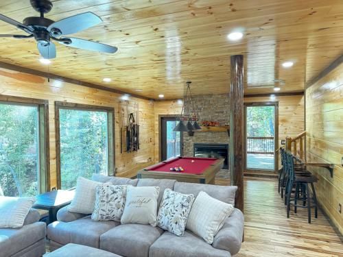 a living room with a couch and a pool table at Lux Cabin Indoor and Outdoor Living in Sevierville