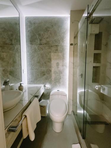 ein Badezimmer mit Toilette, Waschbecken und Dusche in der Unterkunft Manakin Hostal & Resto in Manta
