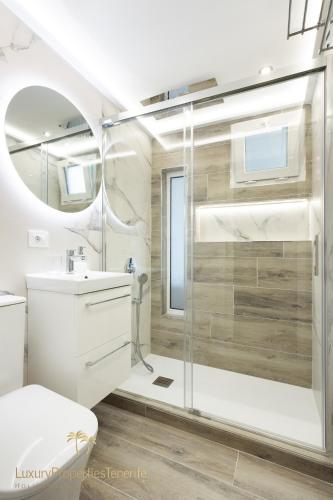 a white bathroom with a shower and a sink at Villa Tropical in Adeje