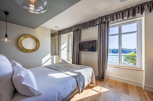 a bedroom with a bed and a large window at Restaurant Hotel Didier Méril in Dinard