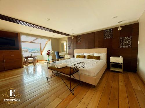 a bedroom with a large bed and a wooden floor at Hotel Ensueños by HHG in Cuenca