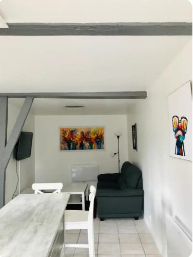 un salon avec un canapé et une table dans l'établissement Charmante petite maison à la campagne, à Soulanges