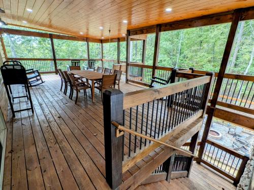 a screened in porch with a table and chairs at Lux Cabin Indoor and Outdoor Living in Sevierville