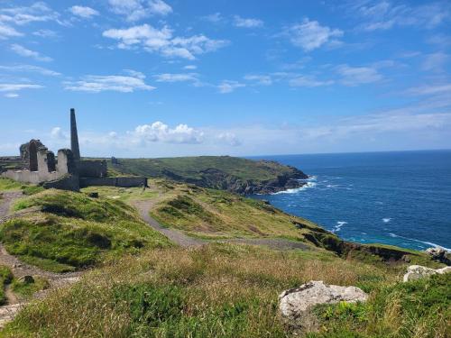 - un vieux bâtiment sur une colline à côté de l'océan dans l'établissement St Just Cottage - Beautiful 3 bed in the heart of St Just with a Fish & Chip Shop, Cafes and 4 local Pubs, à Saint Just