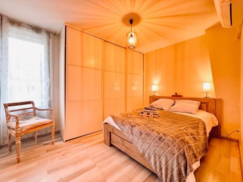 une chambre avec un grand lit et une chaise dans l'établissement Le Montadou avec Roof Top - local vélosmotos - netflix - climatisation, à Cuxac-dʼAude