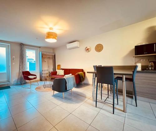 une cuisine et un salon avec une table et des chaises dans l'établissement Le Montadou avec Roof Top - local vélosmotos - netflix - climatisation, à Cuxac-dʼAude