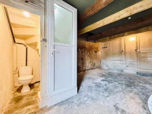 La salle de bains est pourvue de toilettes et d'une porte dans la chambre. dans l'établissement Le Montadou avec Roof Top - local vélosmotos - netflix - climatisation, à Cuxac-dʼAude